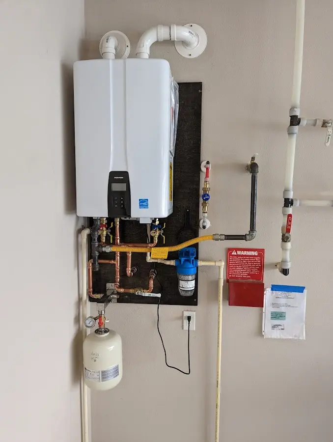 Professional plumber installing copper piping in a Buxton home
